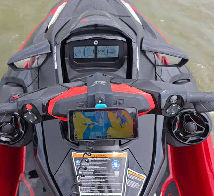 Smartphone mounted on jetski next to marine audio controller